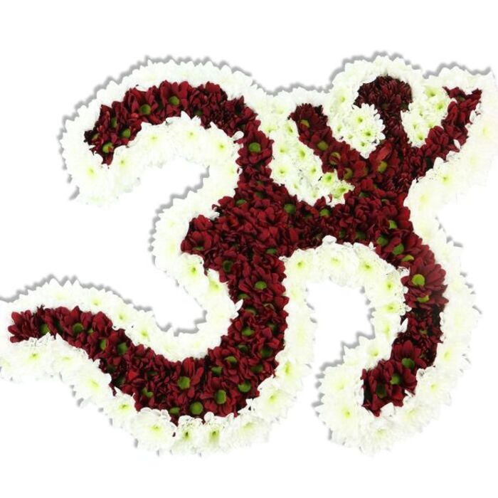 A reverent, handcrafted floral Om sits bold against a clean white background, its iconic Sanskrit form painstakingly rendered in tiny, dark red to maroon chrysanthemum-like blooms. Each small pompon shows a subtle lime-green eye at its center, a botanical punctuation that livens the dense red field and lends a textured, organic shimmer to the symbol's curves. A generous, undulating rim of pristine white spray chrysanthemums frames and defines the entire piece, the white edge carving the negative spaces and accentuating the crescent-and-dot detail at the top of the Om. Studio lighting creates a delicate shadow beneath the composition, reinforcing the three-dimensional, sculptural quality achieved by tight, even packing of thousands of blossoms. The overall impression is one of quiet dignity - a floral tribute meant for devotional altars, memorial services, or meditative gatherings - its colours signaling both solemnity and hope. As a local florist familiar with the area around St Mary Cray, Flower Delivery St Mary Cray would present this arrangement with sensitivity for community rituals, whether placed near the River Cray for an outdoor remembrance or inside a neighbouring temple or community hall near Petts Wood and Orpington. The scent is soft and grounding, the texture cool and densely petalled, and the workmanship deliberate: underlying wires, foam support and patient placement produce a lasting, visually clear symbol that invites contemplation and conveys deep respect.